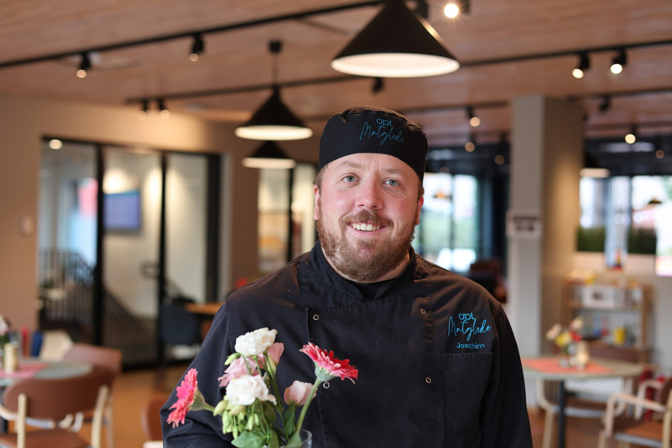 Arbeidstaker som setter ut blomster i bistroen