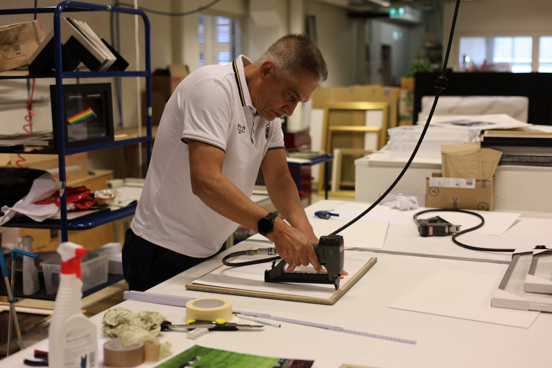 Arbeidsveileder som stifter en bakside på en bilderamme