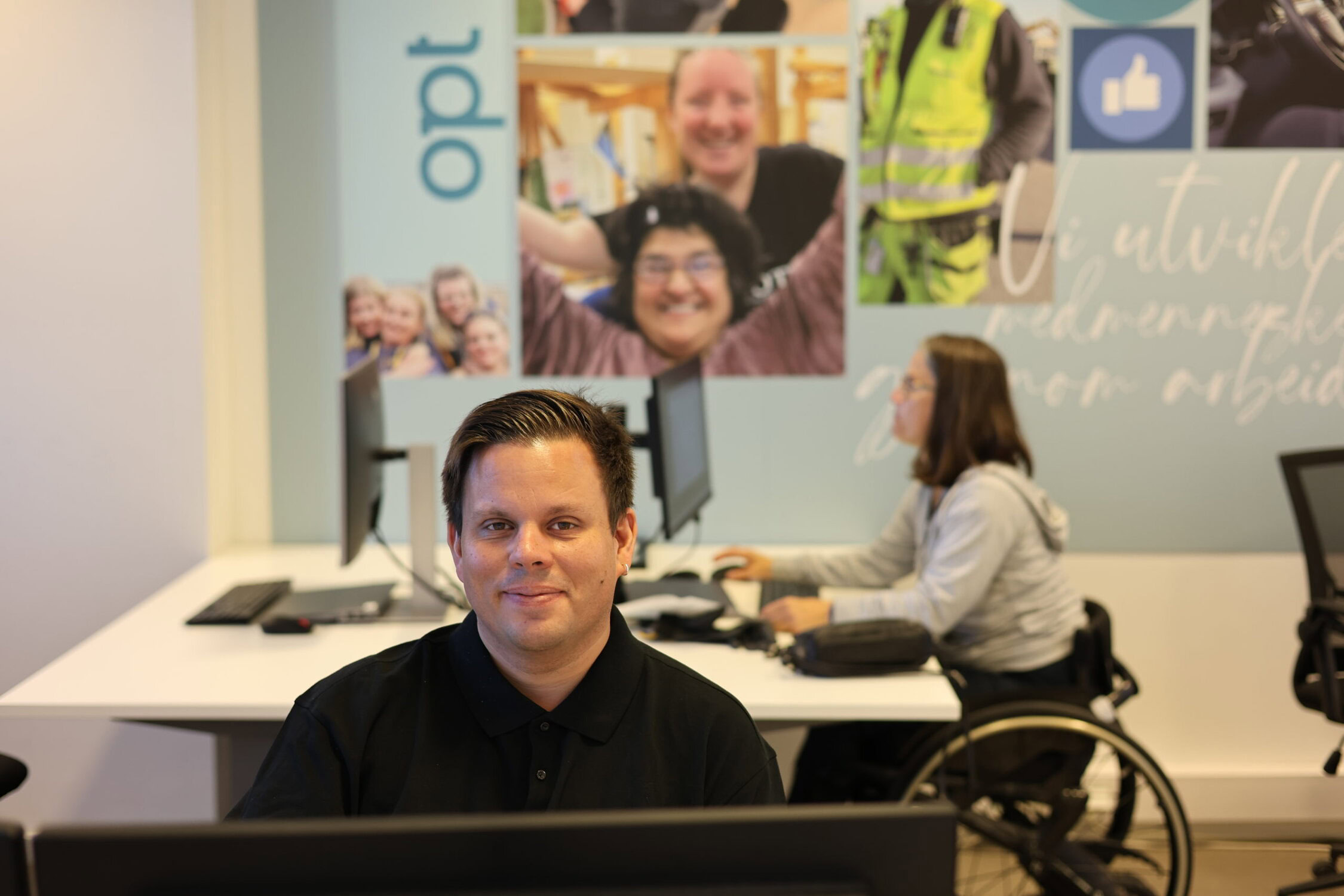 Arbeidstaker som sitter i resepsjonen og smiler